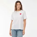 Camiseta de manga corta color blanco con cuello redondo y pequeño corazón rojo estampado en el pecho.