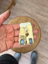 Aros colgantes de bronce reticulado con base irregular y piedra celeste redonda.