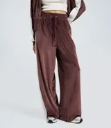 Pantalón wide leg de textura aterciopelada color bordó, con cintura elástica ajustable mediante lazo y franjas laterales en contraste.