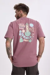 Remera de algodón color verde musgo, de corte clásico con cuello redondo y manga corta. Presenta un pequeño estampado gráfico en el pecho.
