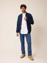 Cardigan de punto en color gris, con cierre frontal completo, cuello tipo mao y puños acanalados. Presenta un pequeño logo bordado en el pecho y detalles en contraste en el interior del cuello y puños.