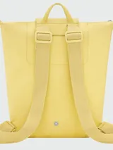 Mochila de diseño minimalista en color beige, con cierre superior de cremallera y solapa frontal con botón a presión. Presenta un asa superior y correas ajustables, con el logo de la marca grabado en la solapa.