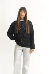 Sweater negro de tejido crochet con mangas largas y cuello redondo.