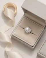 Anillo de plata 925 con diseño floral, compuesto por una perla central rodeada de pétalos decorados con circonias brillantes.