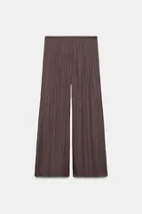 Pantalón de tiro medio, color negro, confeccionado en tejido satinado con diseño de pierna ancha y cintura elástica ajustable con cordón.