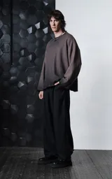 Buzo de cuello redondo con efecto de lavado maltinto o nevado. Presenta un corte oversize con hombros caídos, costuras expuestas a contratono y detalles de roturas desgastadas en el cuello, puños y ruedo.