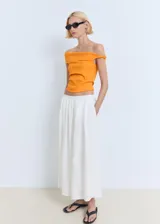 Top asimétrico color naranja, con diseño palabra de honor y fruncido lateral. Es una prenda entallada sin mangas.