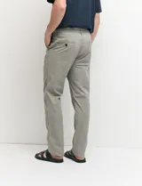 Pantalón tipo chino de corte slim moderno, de color gris, con bolsillos funcionales delanteros e italianos y detalles de costura premium.