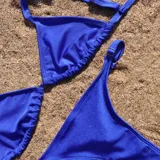 Bikini de dos piezas color azul eléctrico, con corpiño triangular de breteles regulables y bombacha colaless o semivedetina con breteles laterales regulables.