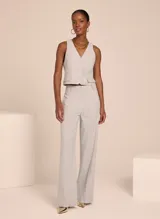 Chaleco sastrero color gris claro con patrón de cuadros, escote en V, cierre frontal con botones y bolsillos delanteros decorativos.