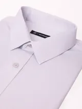 Camisa de vestir de manga larga con cuello clásico y cierre frontal de botones. Presenta un estampado de micro-patrón geométrico en tonos azules.