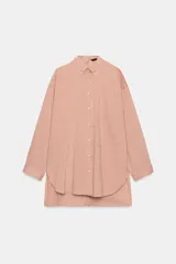 Camisa de cuello solapa y manga larga con estampado de rayas verticales. Presenta un bolsillo de plastrón en el delantero, cierre frontal con botones y detalle de botones en la espalda. Su diseño cuenta con un bajo asimétrico y aberturas laterales.