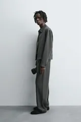 Pantalón regular fit color marrón oscuro, confeccionado en tejido con viscosa. Cuenta con cintura elástica, bolsillos delanteros y detalle de bolsillos traseros de vivo. El cierre frontal es con cremallera y botón.