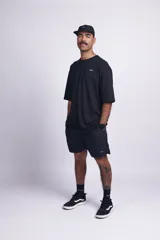 Short de baño negro liso con cintura elástica, bolsillos laterales y trasero con velcro, suspensor interno y etiqueta en el frente.