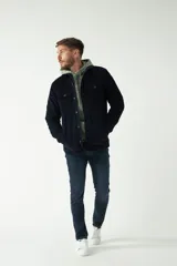 Chaqueta de pana azul marino con interior capitoneado y bolsillos con botones.