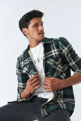 Sobrecamisa de algodón a cuadros color ladrillo, con interior de corderito, cierre con botones, bolsillos tipo cartera y logo en goma. El modelo usa talle M.