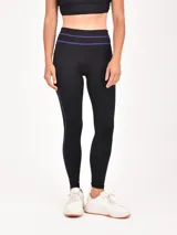 Calza deportiva negra con detalles de costuras en color violeta en la cintura y los laterales.