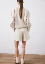 Short de algodón color beige, de corte sastrero con tiro alto y bolsillos laterales.