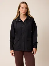 Campera de estilo deportivo color negro, con capucha ajustable, cierre frontal oculto por solapa con botones a presión y dos bolsillos frontales con solapa.
