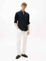 Camisa de manga larga Tommy Hilfiger color azul marino, de corte regular, confeccionada en popelina elástica de algodón regenerativo, algodón BCI y elastano. Presenta cuello clásico, cierre con botones, puños abotonados y logo bordado en el pecho.