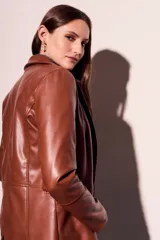 Trench marrón de cuero vegano, corte al cuerpo y largo hasta la rodilla.