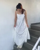 Vestido largo blanco de tirantes finos, con escote en V y falda con volados.