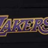 Short deportivo negro con cintura elástica ajustable con cordón, logo de los Lakers en la pierna izquierda y la palabra "Lakers" en vertical en la pierna derecha.