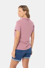 Camisa lisa de lino color beige, de manga corta, con cuello camisero, bolsillo ojal en el pecho y cierre frontal con botones.