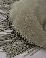 Cartera tipo hobo de gamuza color beige, con diseño amplio y detalle de flecos largos en todo el contorno. Cuenta con un asa superior con pespuntes artesanales y cierre principal.