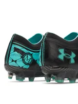 Championes de fútbol Under Armour Magnetico Elite, color negro con detalles en verde agua. Presentan tecnología UA Clone para un ajuste personalizado, impresión 3D para mayor control y zona de golpeo de silicona. Cuentan con cuello de punto tipo calcetín y suela ligera con tacos mixtos para superficies naturales firmes.