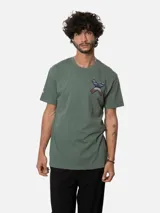 Remera blanca de algodón orgánico con cuello redondo y manga corta. Presenta un estampado en el pecho con una cruz formada por dos tablas de surf en tonos rojo, azul y negro.