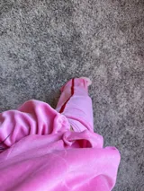 Pantalón de plush rosa chicle con elástico en la cintura y cierres en los tobillos.