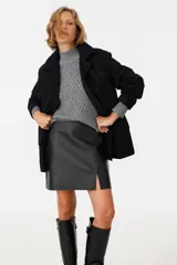 Tapado negro con cuello solapa, de corte recto y largo hasta la rodilla.