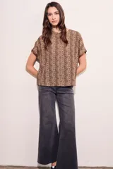 Blusa color beige con estampado animal print en marrón, de corte holgado y mangas cortas.