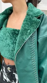 Campera de cuero oversize con solapa amplia de corderito, mangas anchas y detalle de cuero trenzado en la parte delantera.