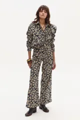 Pantalón de lino estampado con flores pequeñas en tonos crema y marrón sobre fondo azul marino. El pantalón es de tiro medio y tiene un corte ligeramente ancho en las piernas.