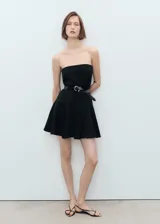 Vestido corto negro sin mangas, con escote palabra de honor, diseño evasé y cierre de cremallera en la parte posterior.