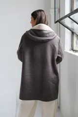 Tapado de corte largo en color gris, confeccionado con interior y detalles en corderito color beige. Presenta cierre frontal, capucha amplia y puños con vuelta en corderito.