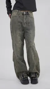 Pantalón de jean color marrón con efecto gastado, corte recto y diseño con paneles geométricos.