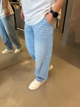 Jean de corte barrel y silueta oversize, en tono azul claro con efecto lavado. Presenta un diseño de tiro medio y pernera amplia que se estrecha ligeramente hacia el tobillo.
