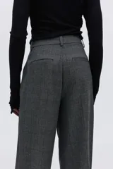 Pantalón sastrero gris oscuro con estampado a cuadros, pinzas, cierre oculto, bolsillos al bies y piernas amplias con pliegues.