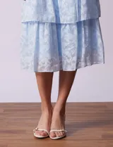 Vestido midi celeste de gasa estampada, marca Julia Jordan. Tiene escote en V, mangas cortas con volados y forro interno a tono.