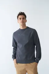 Buzo de felpa gris oscuro con logo estampado en el frente, cuello redondo, mangas largas y puños.