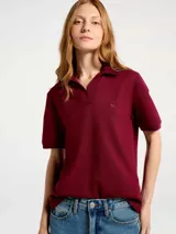 Remera tipo polo de manga corta en color bordeaux, confeccionada en tejido piqué, con cuello clásico y escote en V sin botones. Presenta un pequeño logo bordado en el pecho.