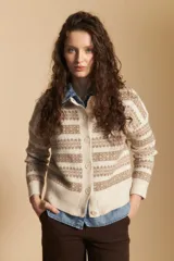 Cardigan corto de tejido jacquard con diseño geométrico en tonos beige y crema, con cierre frontal de botones y cuello redondo.