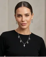 Set de joyería en acero quirúrgico compuesto por un collar de cadena fina con seis dijes de cruz colgantes y un par de caravanas a juego con diseño de cruz.