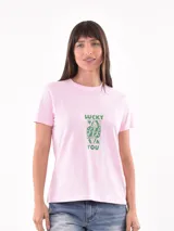 Remera de algodón color rosado, con cuello redondo, mangas cortas y estampa frontal en color verde con la frase 'LUCKY YOU' y un diseño de carta de juego.
