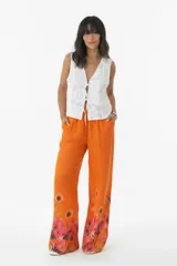 Pantalón palazzo de lino color celeste con cintura elastizada y estampado floral en el ruedo.
