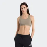 Top deportivo New Balance color beige topo, de soporte medio, con escote redondo y espalda tipo nadador con tirantes ajustables.