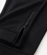 Pantalón deportivo de corte slim para hombre, confeccionado en poliéster color negro. Presenta cintura elástica con cordón de ajuste, bolsillos laterales y diseño ajustado en muslos y rodillas.